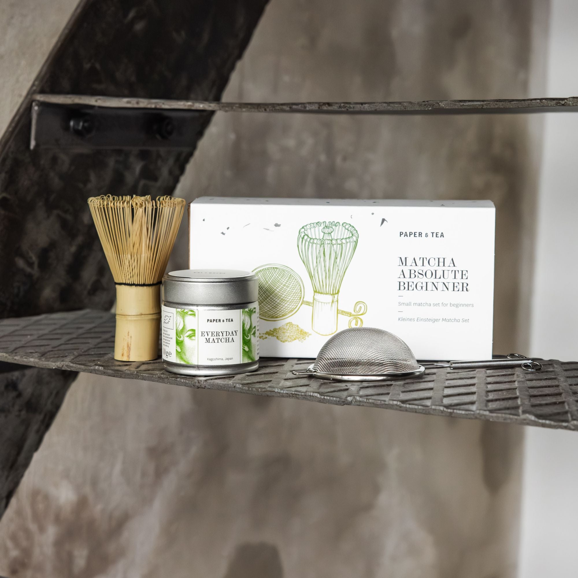 Rustikales Metallregal mit P&T Einsteiger-Matcha-Set inklusive Bambusbesen, Matcha-Dose und Teesieb.