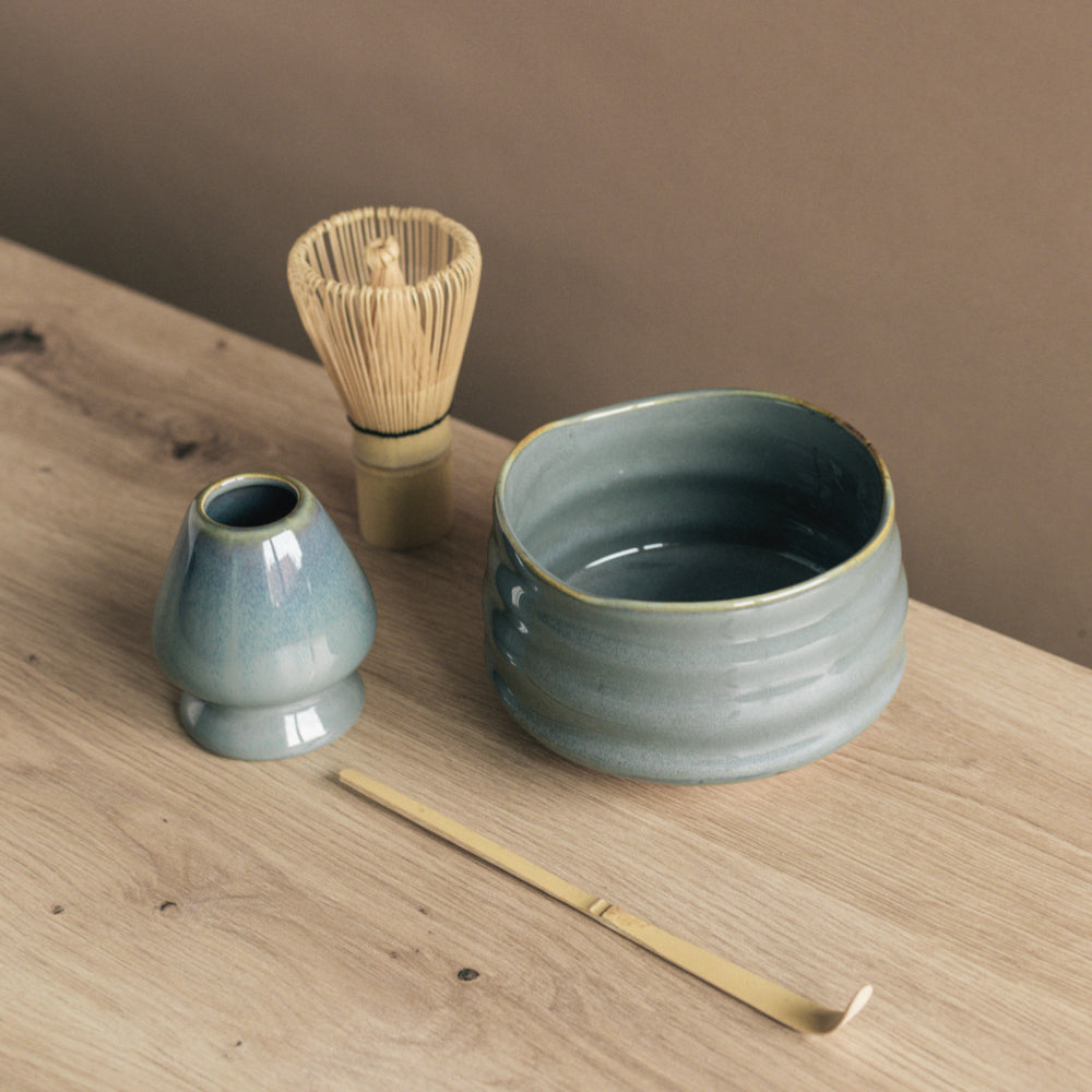 Handgefertigtes blau-graues Keramik-Teeschalen-Set mit Bambusbesen und Löffel auf Holz