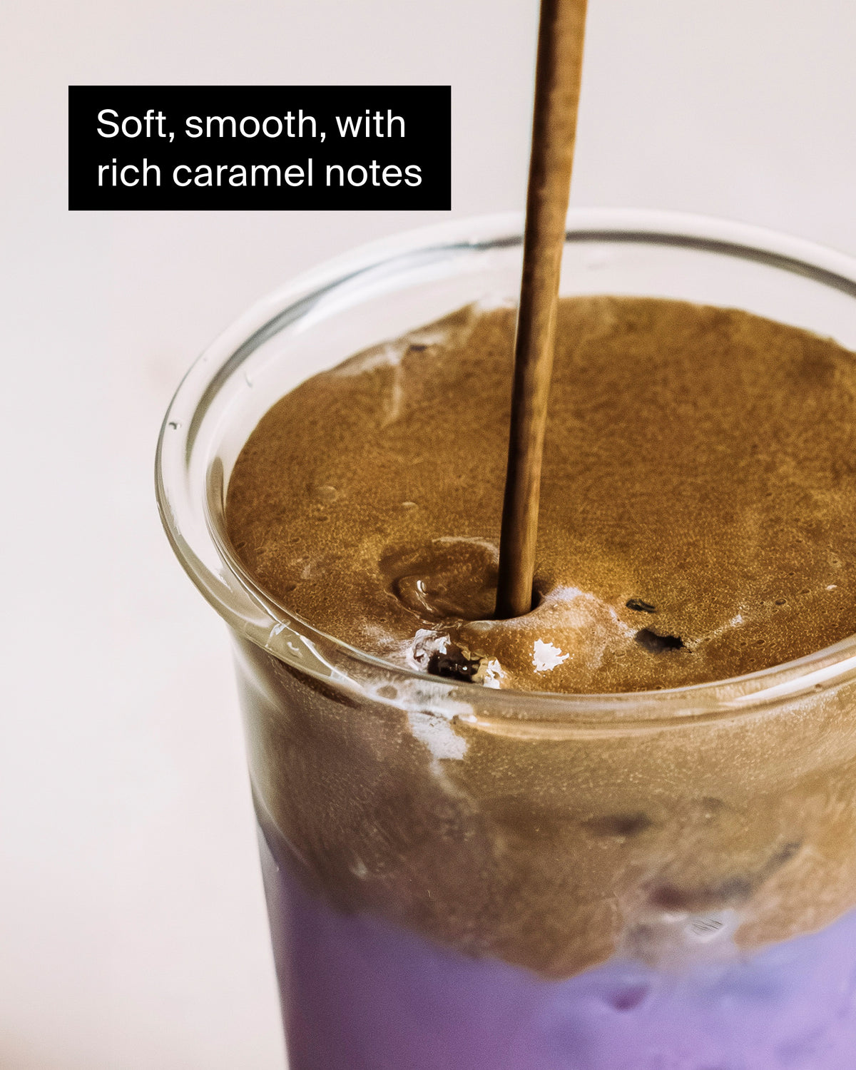 Zweifarbiger Drink mit cremigem Karamellschaum und glattem lila Getränk unten.