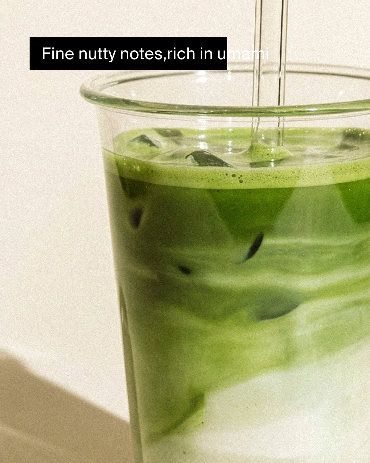 Glas mit grünem Matcha-Eistee und Milch, sichtbare Eiswürfel, feine Umami-Noten