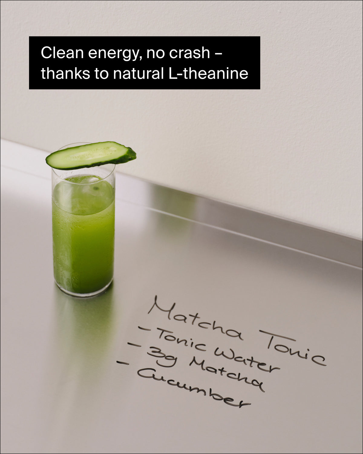 Matcha Tonic in hohem Glas mit Gurkenscheibe auf Edelstahl, natürliche Energie durch L-Theanin