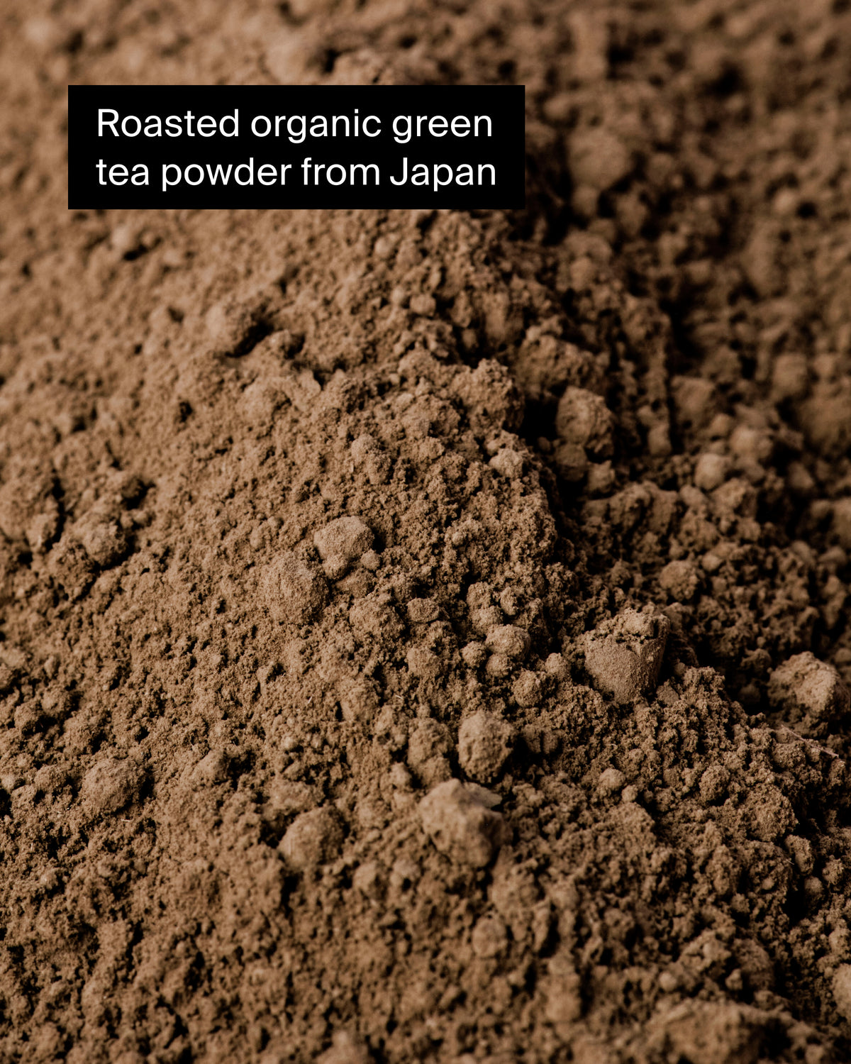Nahaufnahme von geröstetem Bio-Grünteepulver aus Japan mit klumpiger Textur in Brauntönen.