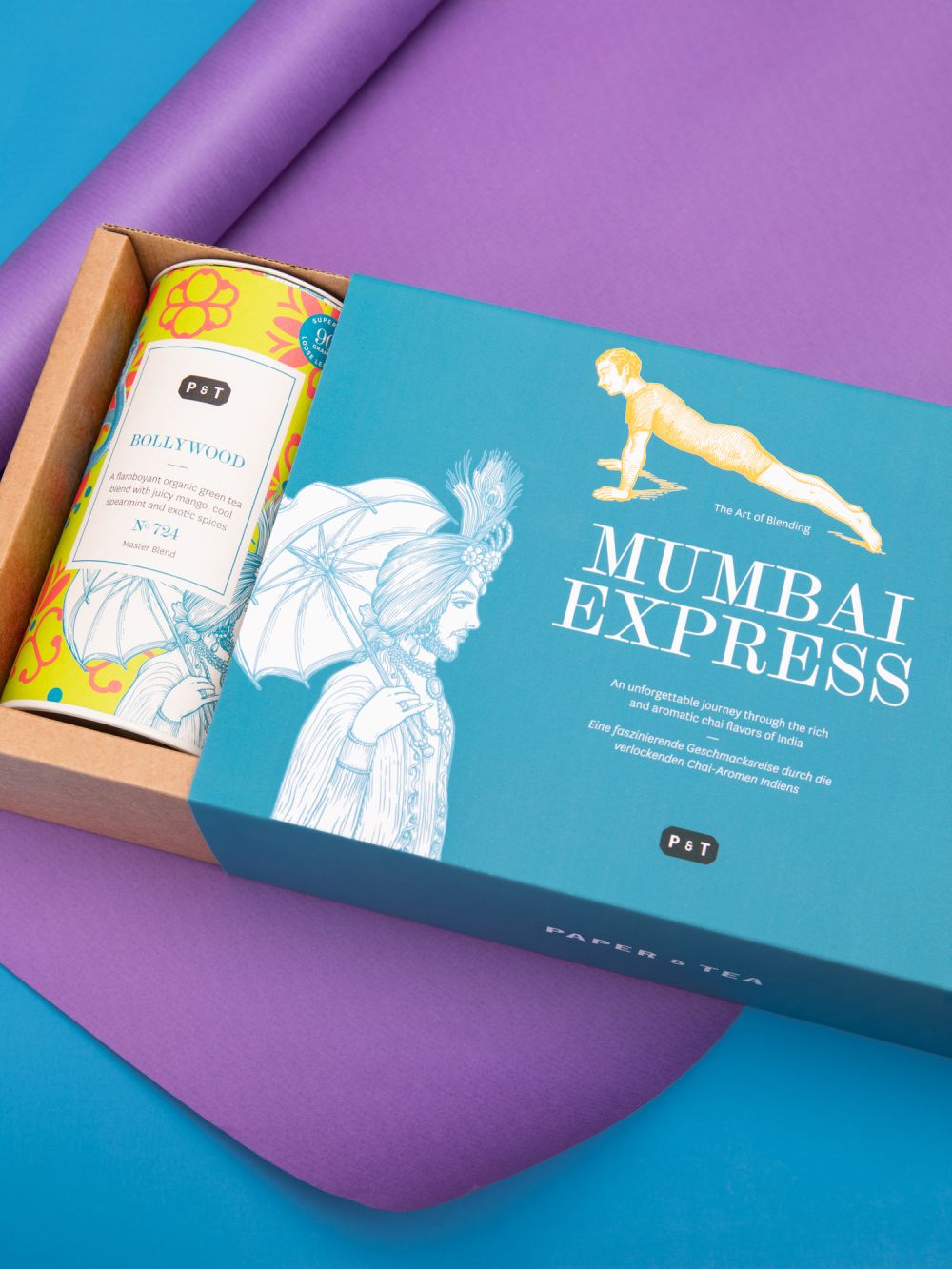 Premium-Teegeschenkset mit MUMBAI EXPRESS Teebox und BOLLYWOOD Bio-Grüntee-Dose auf blauem Hintergrund