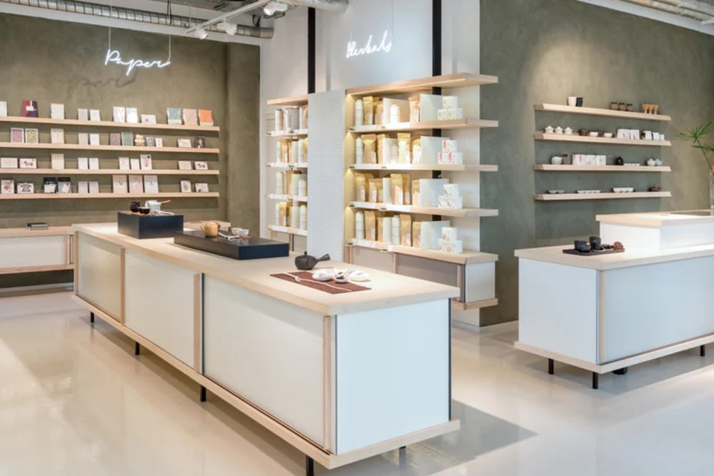 Modernes Geschäft mit Holztheken, die Teekannen, Tassen und Keramikregale präsentieren.